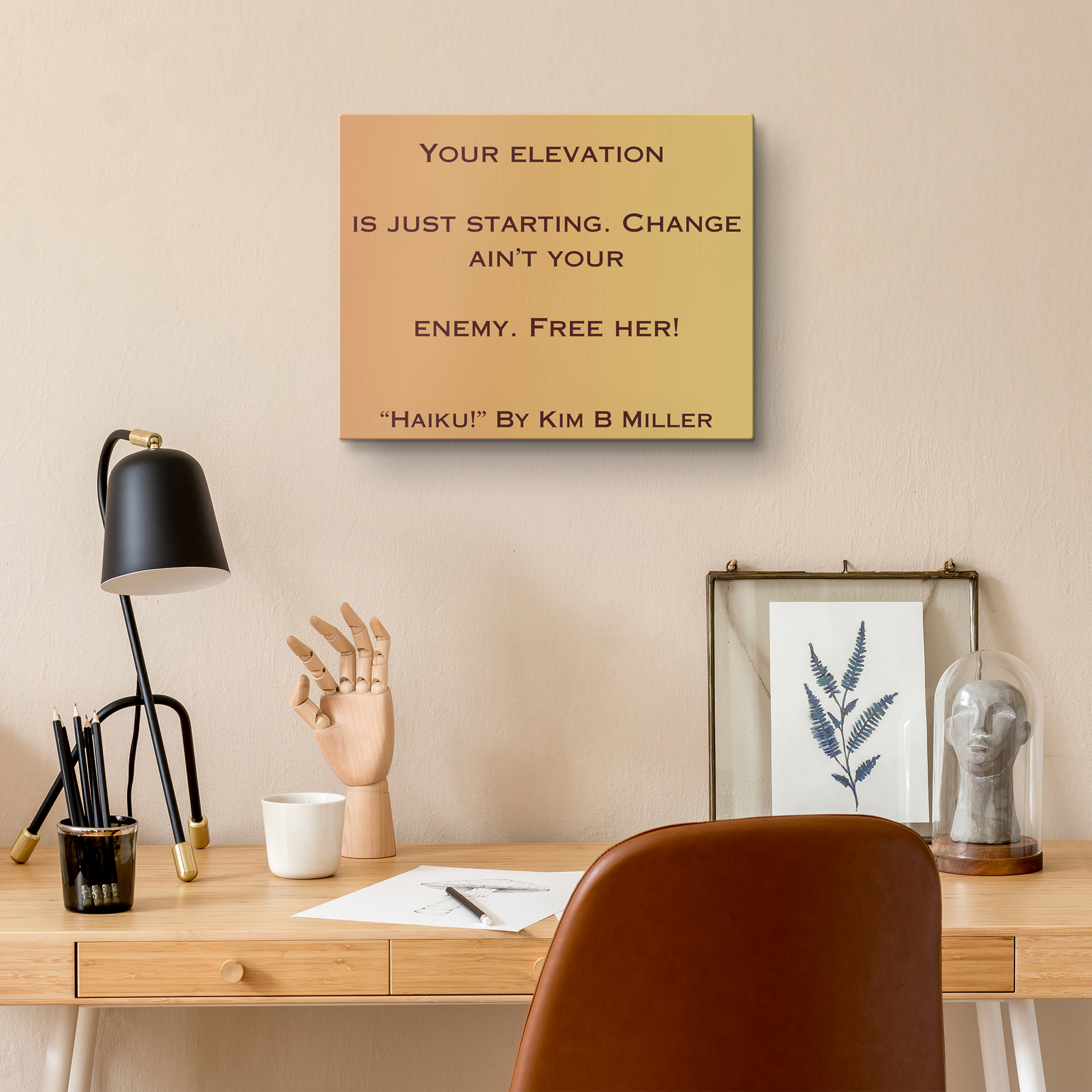 A canvas with a warm yellow-to-orange gradient, featuring an original haiku by Kim B Miller, above a desk.
